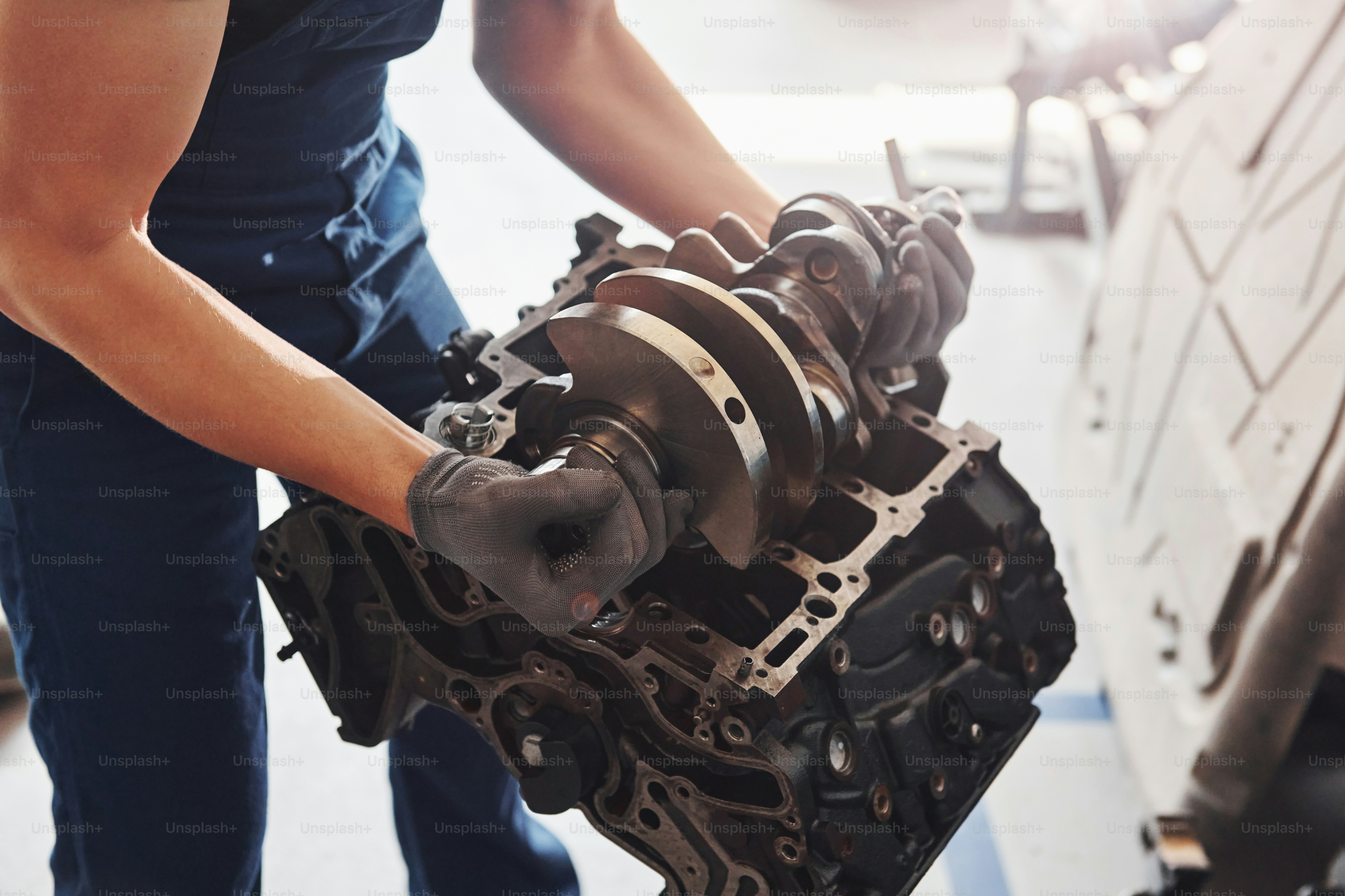 Professioneller Reparaturarbeiter arbeitet mit kaputtem Automotor.
