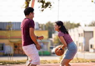 Pareja joven jugando al baloncesto.