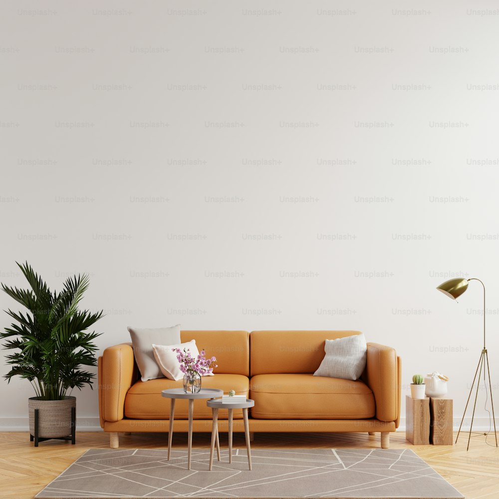 Maqueta de pared interior de sala de estar en tonos cálidos con sofá de cuero sobre fondo de pared blanco.3d renderizado
