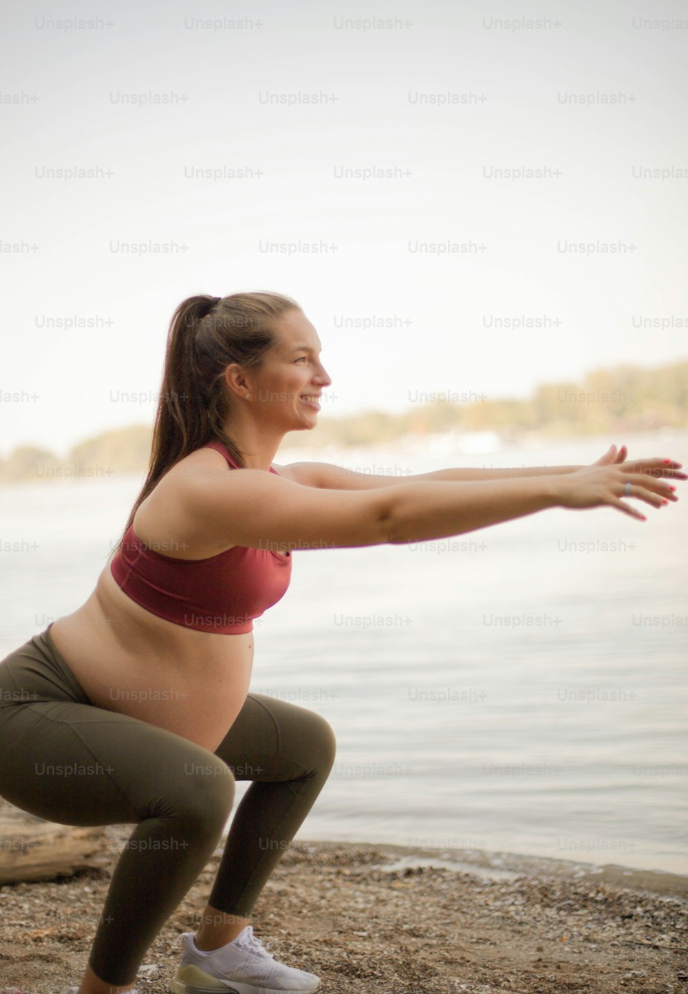 Pregnant woman working yoga on the beach.