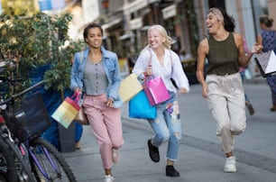 Three women on the street with shopping bags.