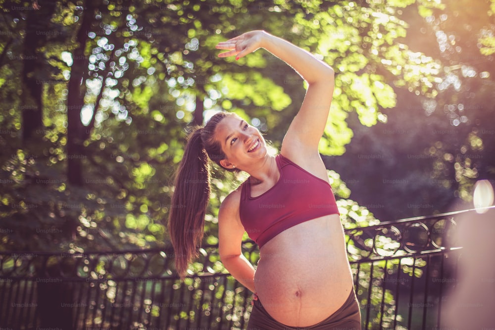 Pregnant woman working exercise outside.