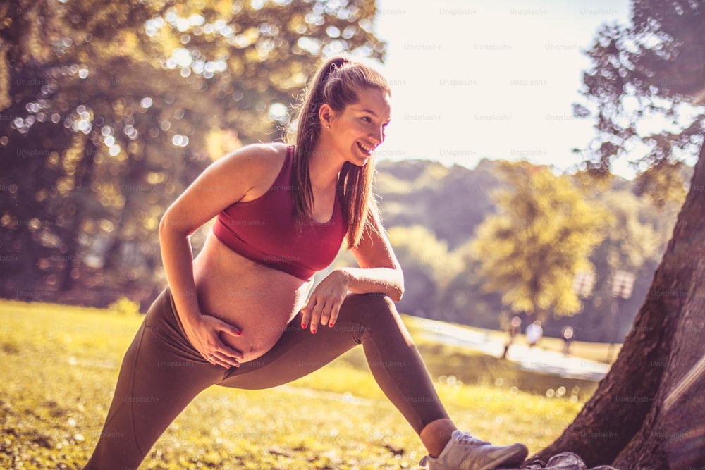 Pregnant woman has exercise in the nature.
