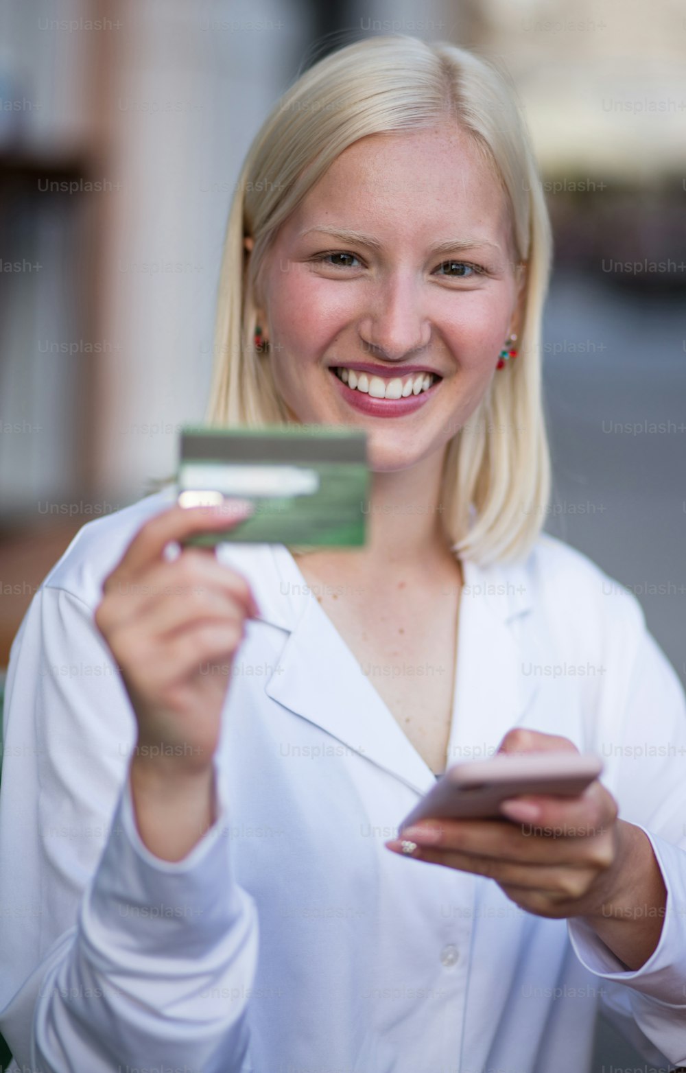 Mulher usando o telefone inteligente e cartão de crédito para compras on-line no café.