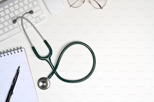 Stethoscope, notebook and glasses on white background.