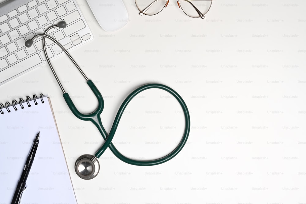 Stethoscope, notebook and glasses on white background.