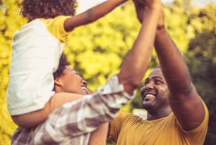 African American family having fun outdoors. Focus is on background.