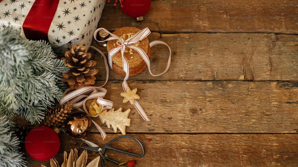 크리스마스 쿠키, 세련된 선물, 소박한 나무 테이블에 축제 장식. 분위기 있는 크리스마스 파노라마 플랫에는 텍스트를 위한 공간이 있습니다. 크리스마스 선물, 건강한 오트밀 쿠키, 장식품