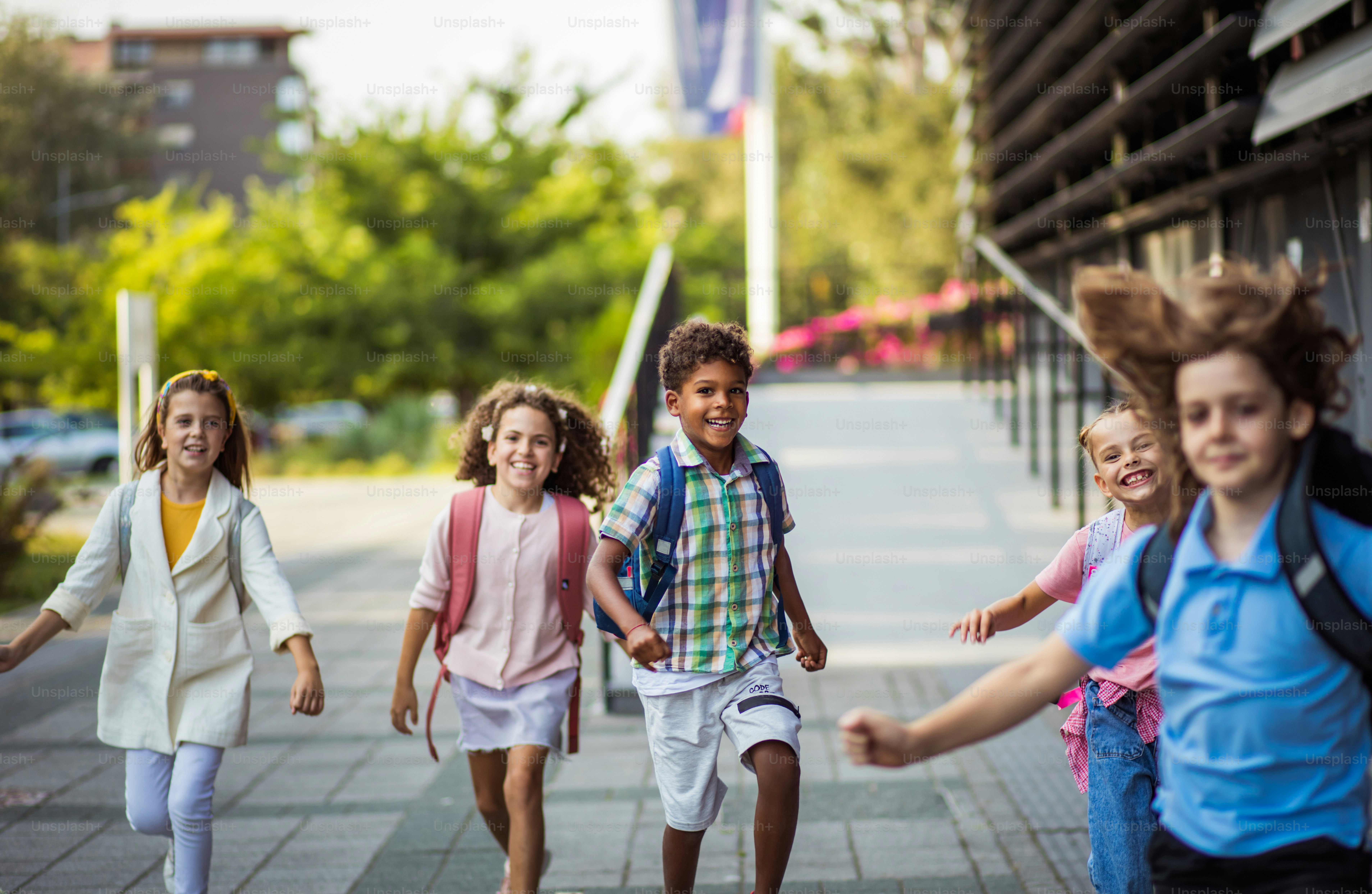 Group of elementary age schoolchildren outside. School kids going to school together.