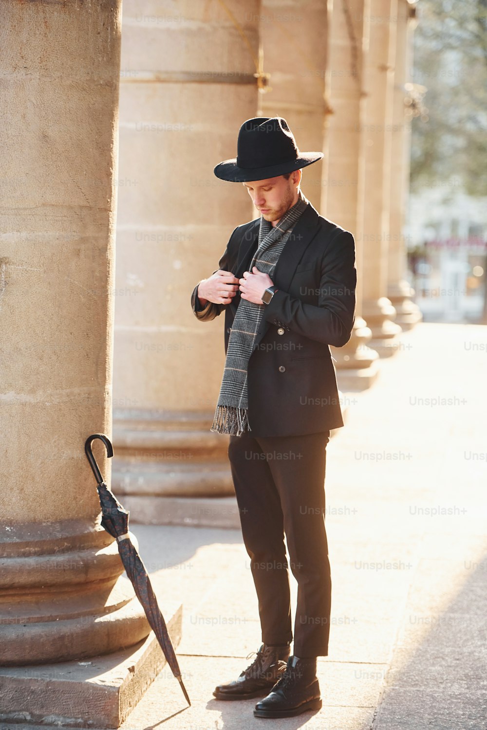 Jeune homme élégant dans des vêtements formels et élégants à l’extérieur de la ville.