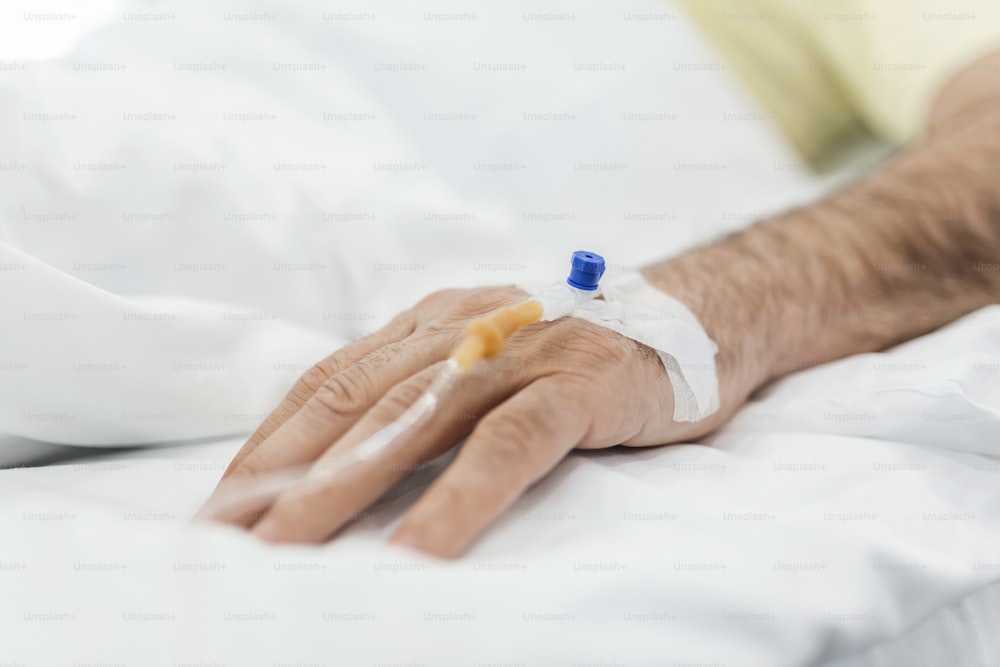 Image recadrée d’une perfusion intraveineuse sur la main du patient.