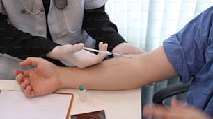 Foto recortada del médico administrando la inyección al paciente.