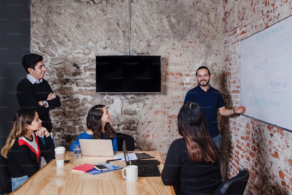 Jovem empresário mexicano discutindo um plano de negócios com seus colegas de trabalho na sala de conferências do escritório