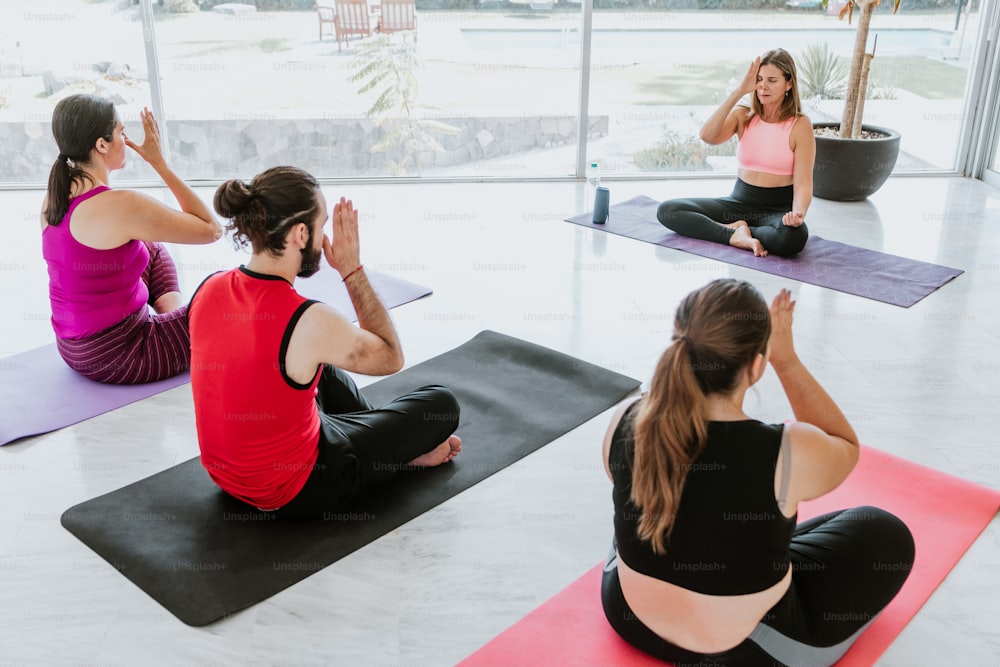 Young hispanic people practicing yoga breathing techniques with an instructor in Latin America