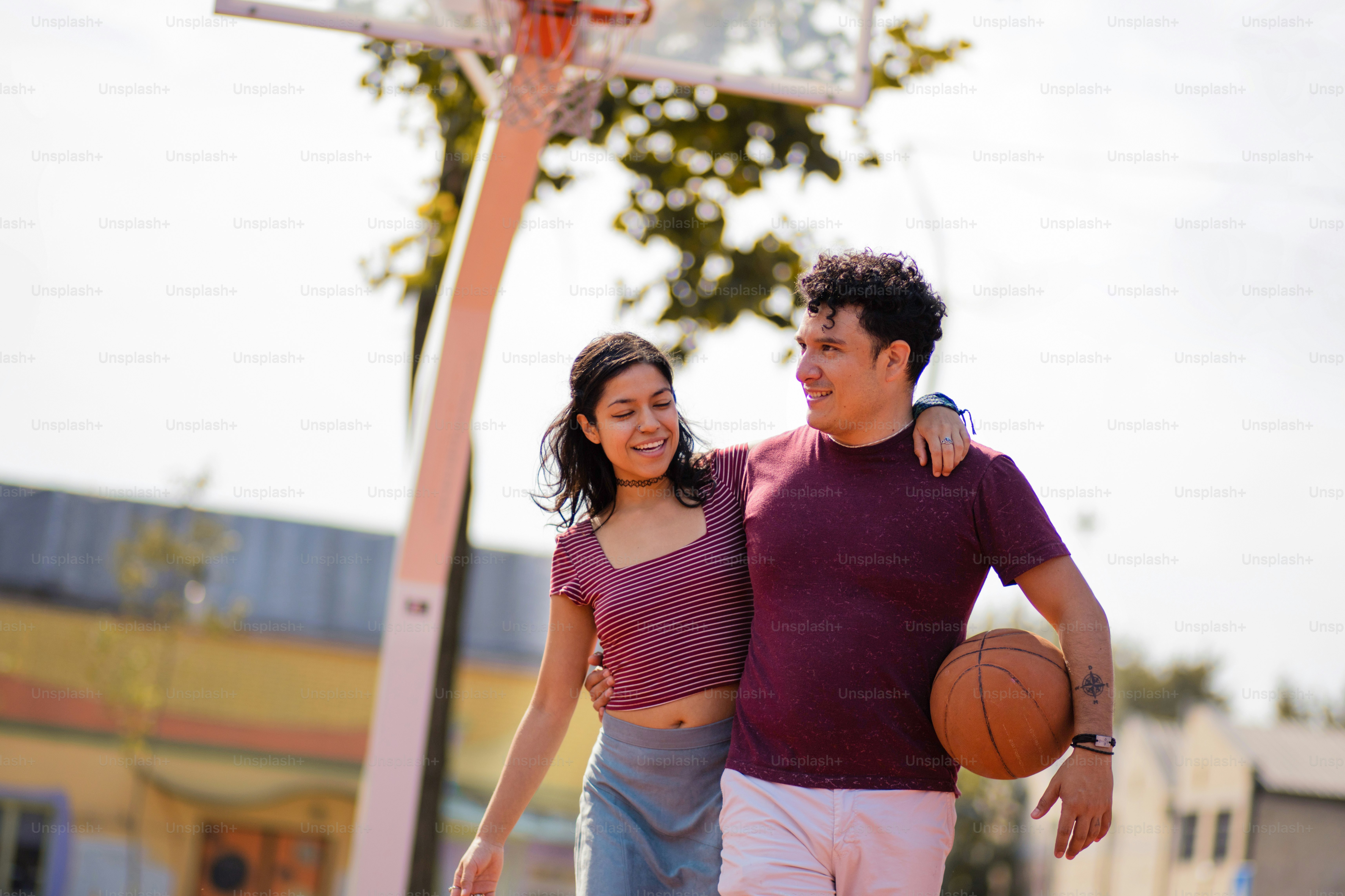 Couple avec ballon sur le terrain de basket-ball.