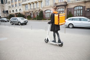 Young male person looking forward while looking for address of delivery