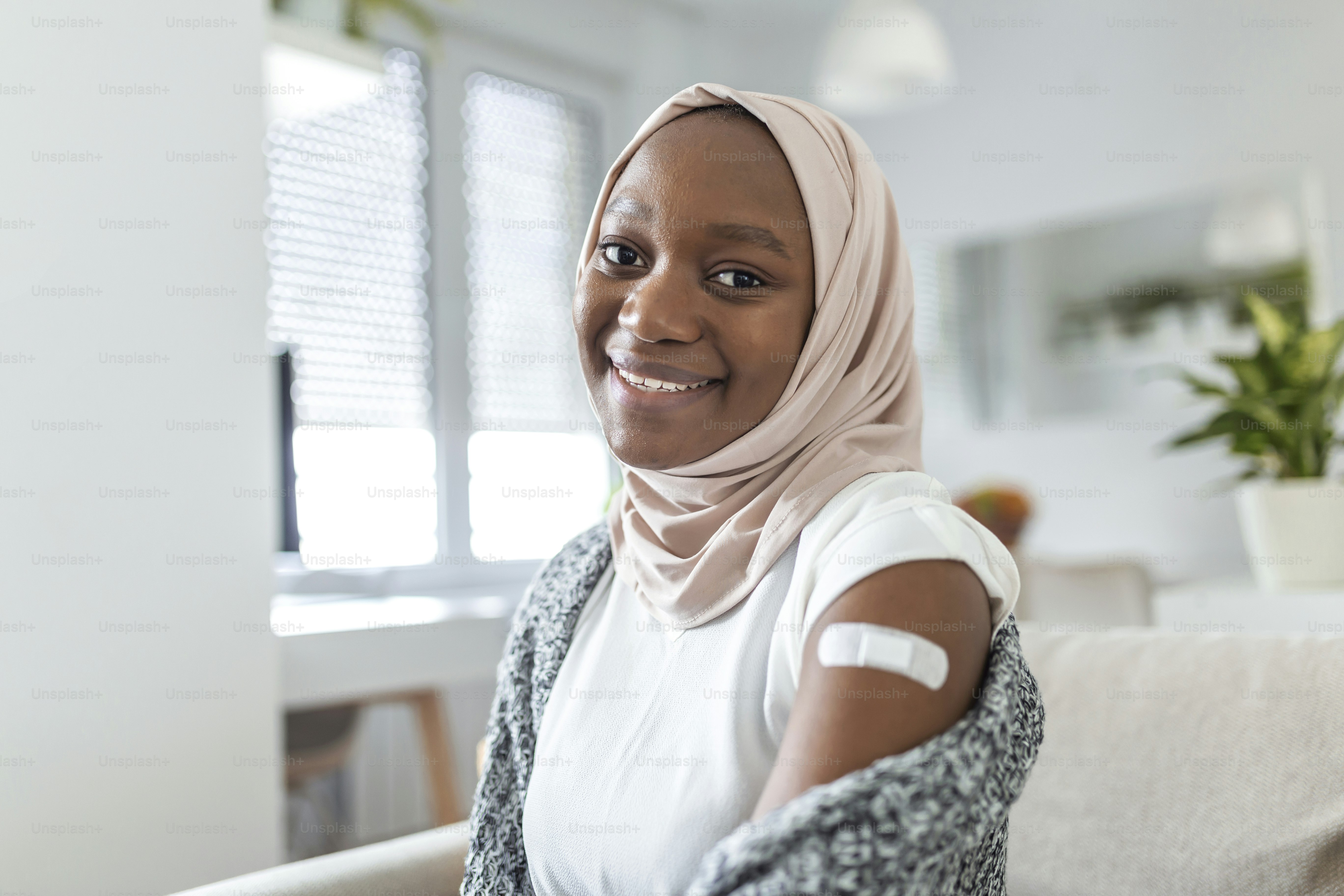 Adhesive bandage on arm after injection vaccine or medicine,ADHESIVE BANDAGES PLASTER - Medical Equipment,Soft focus Adhesive bandage on a muslim african female brachium after covid-19 vaccination