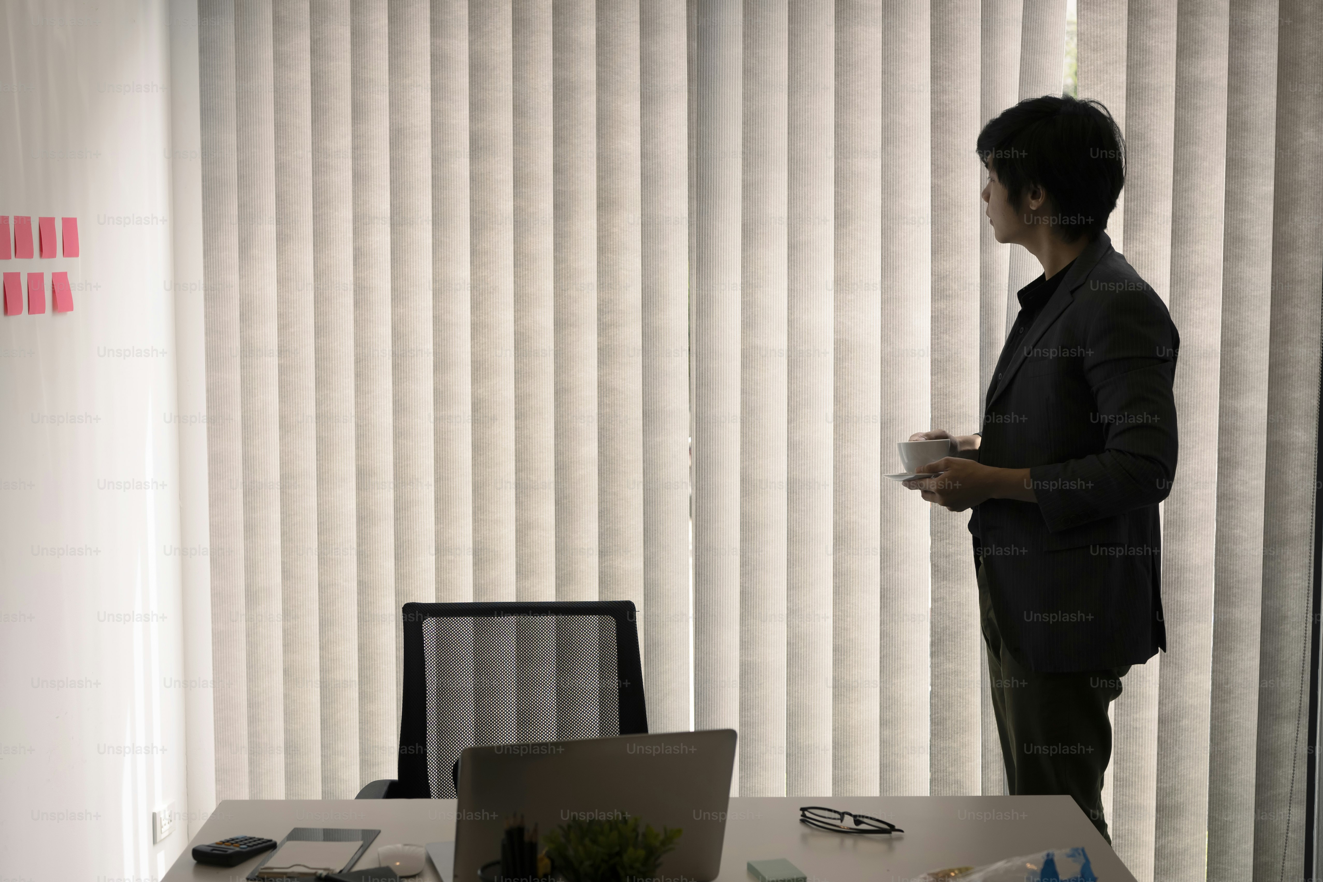 Hombre de negocios pacífico parado en su habitación y bebiendo café.