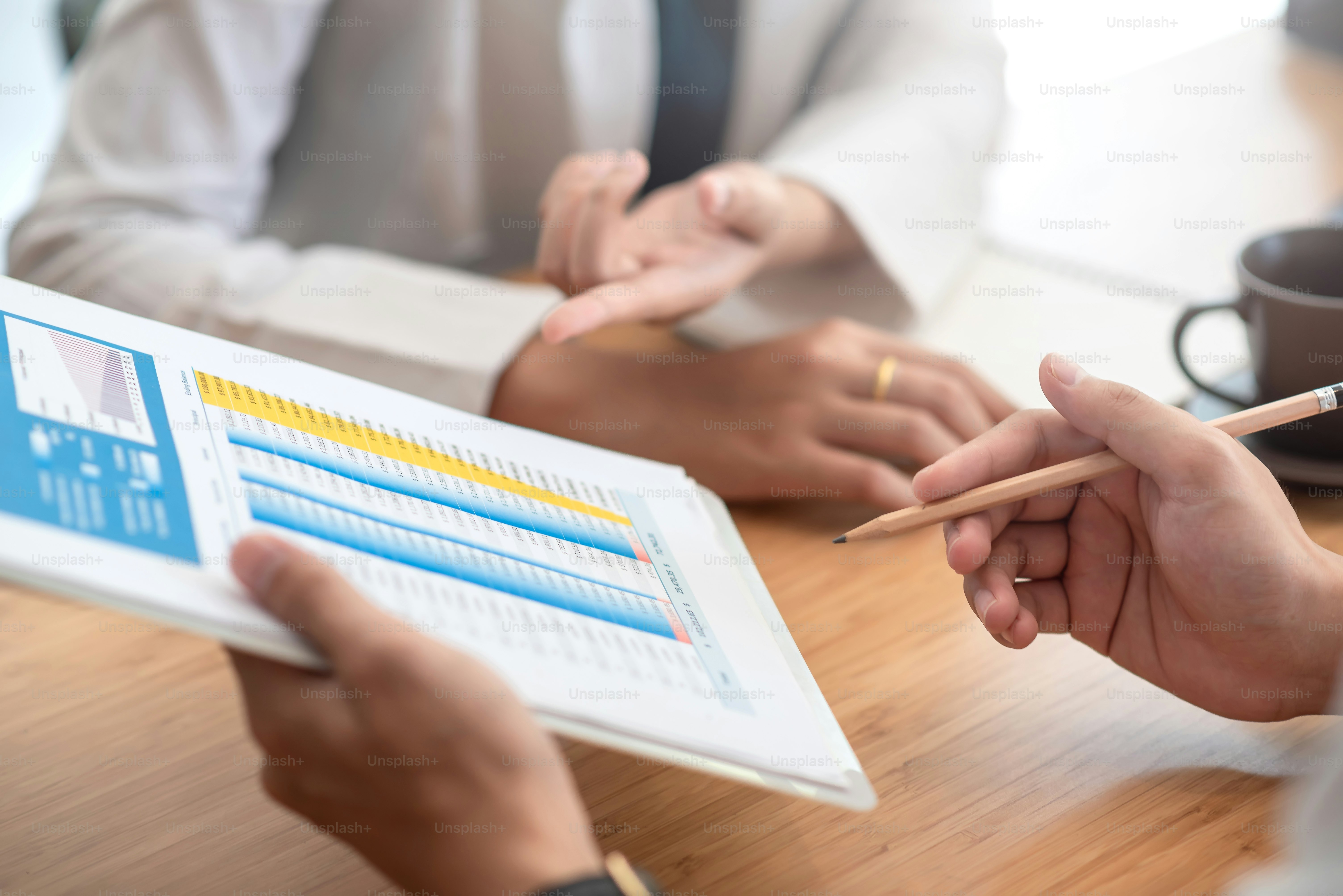 Close-up. Two business people analyzing. work statistics using graph at ...