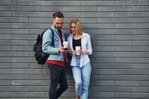 Young stylish man with woman in casual clothes outdoors together. Conception of friendship or relationships.