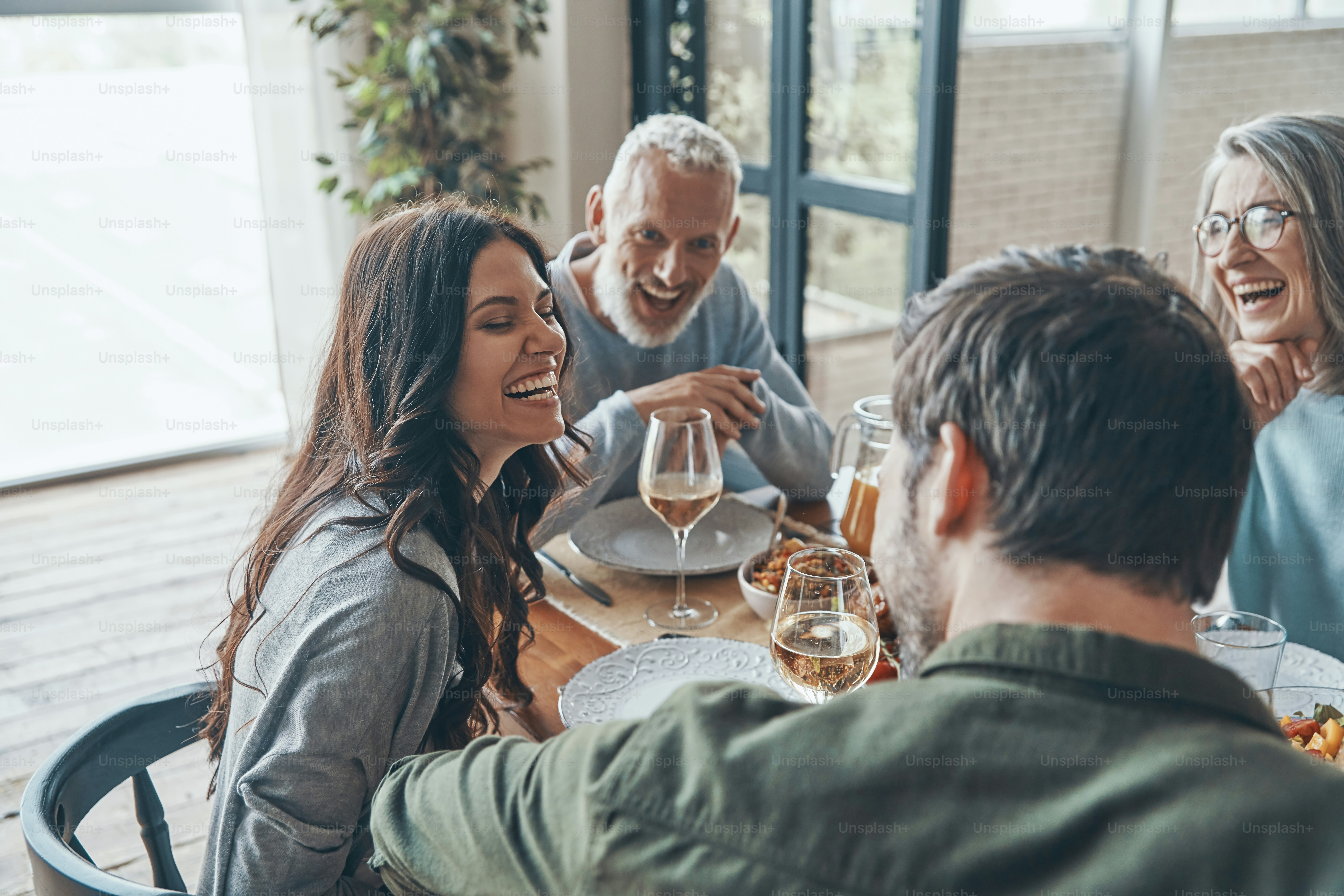 Happy family communicating and smiling while having dinner together