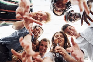 Looking down. View from below. Group of young people in casual clothes have a party at rooftop together at daytime.