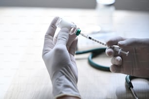 Médecin ou infirmière tenant une seringue d’injection et un vaccin.