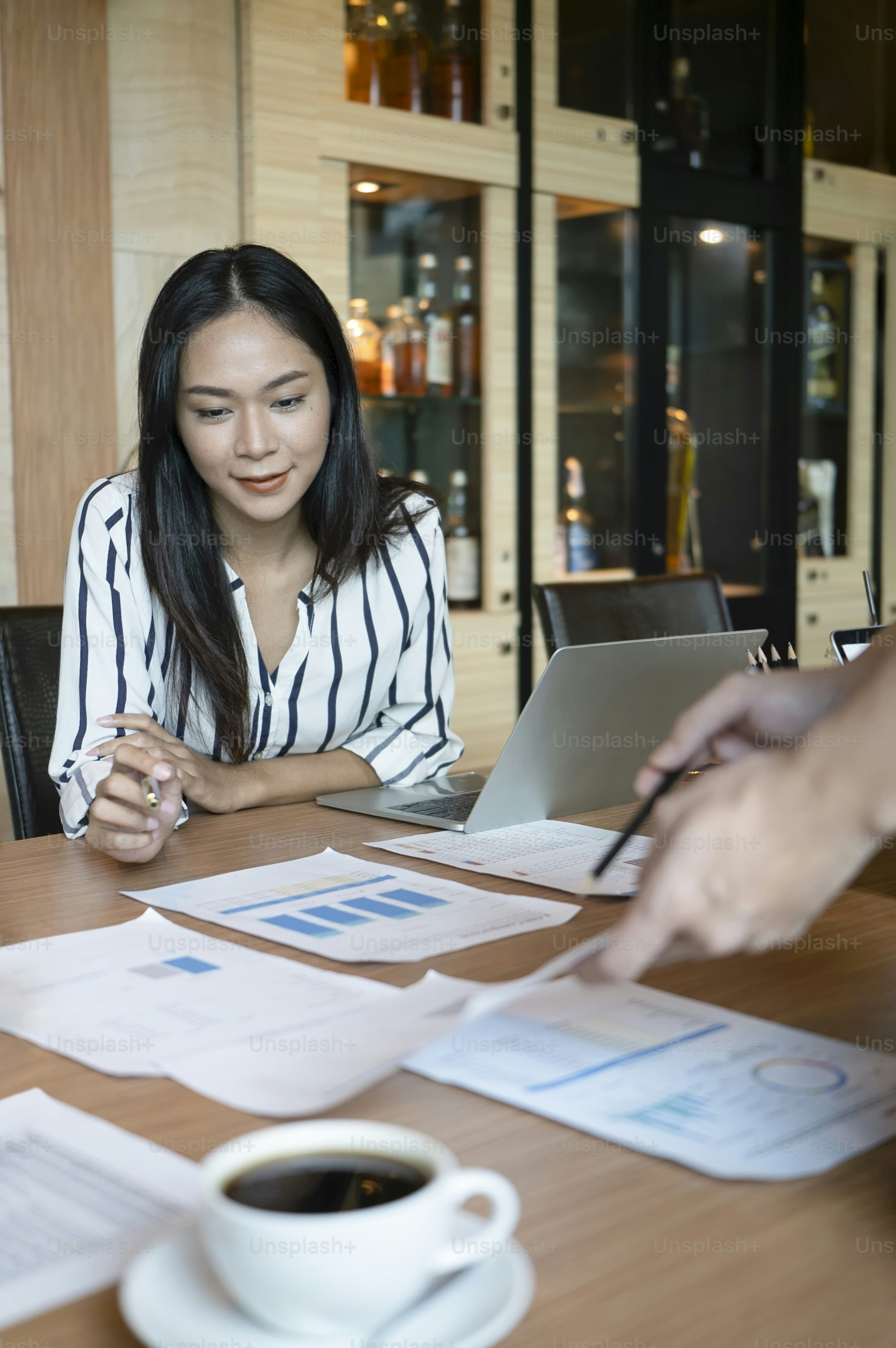 Gruppe von Geschäftsleuten, die Geschäftsdokumente im Besprechungsraum analysieren.
