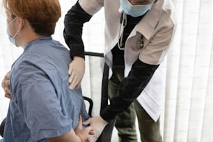 Médico examinando a un paciente que sufre de dolor de espalda.