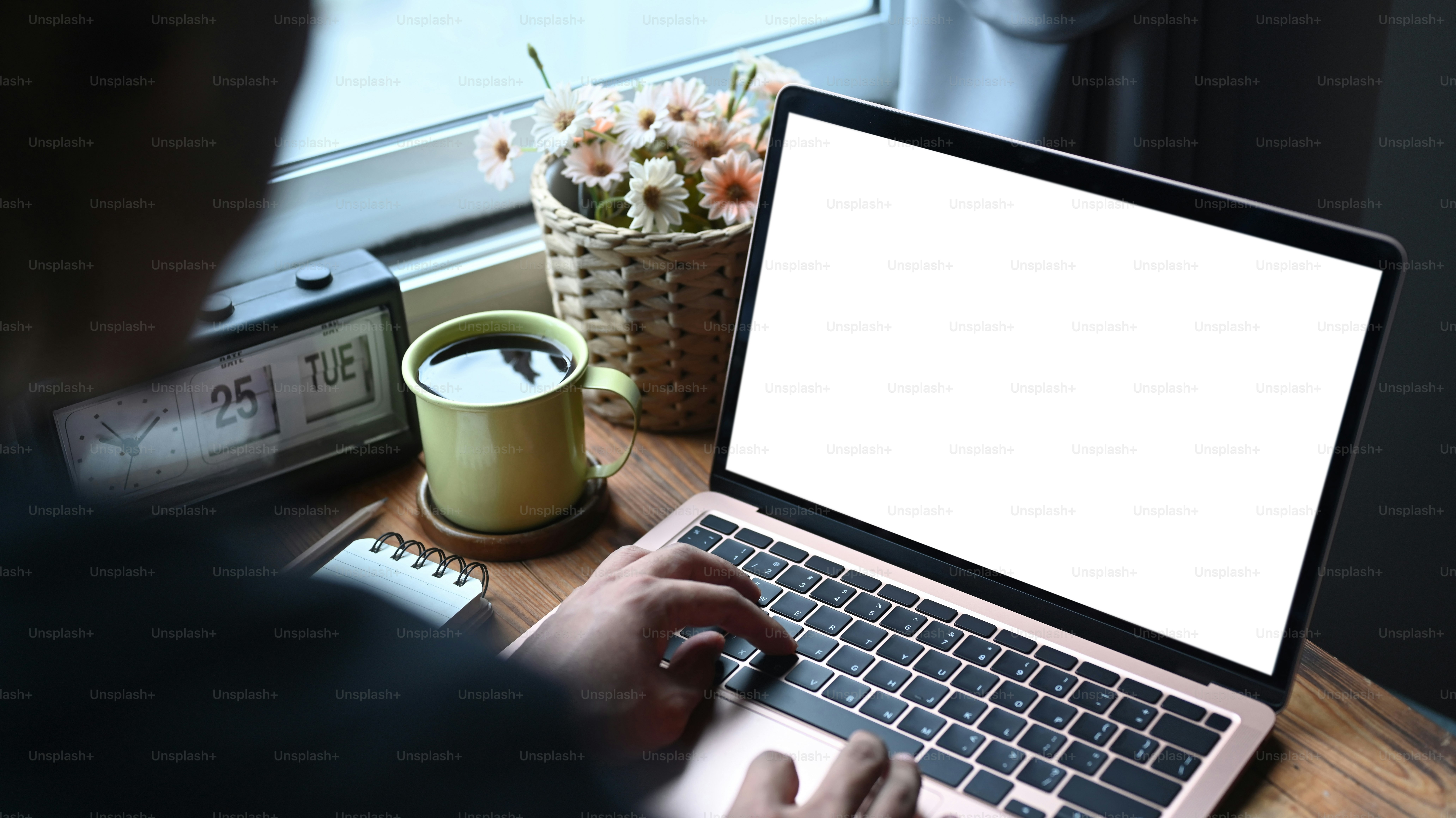 View over shoulder businessman working with laptop in bright office.