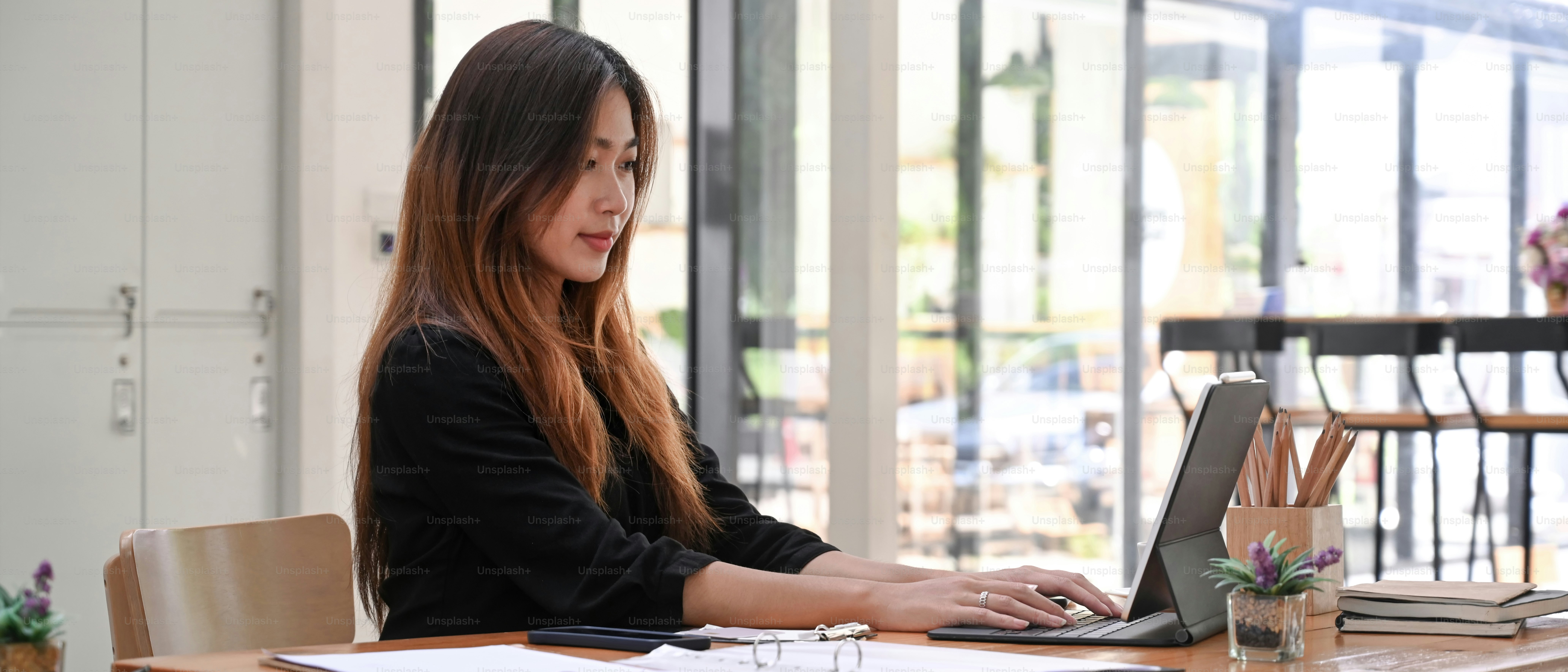 Young female designer working online with computer tablet at office.
