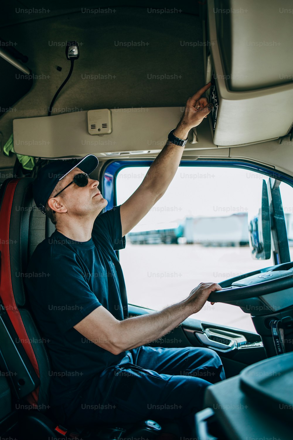 Motorista de caminhão experiente sentado em seu caminhão e esperando por uma nova rota de condução.