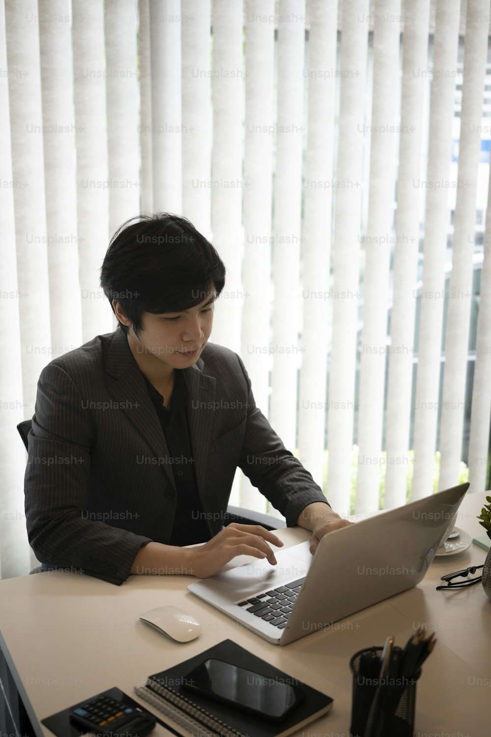 Businessman checking email on laptop computer at office.