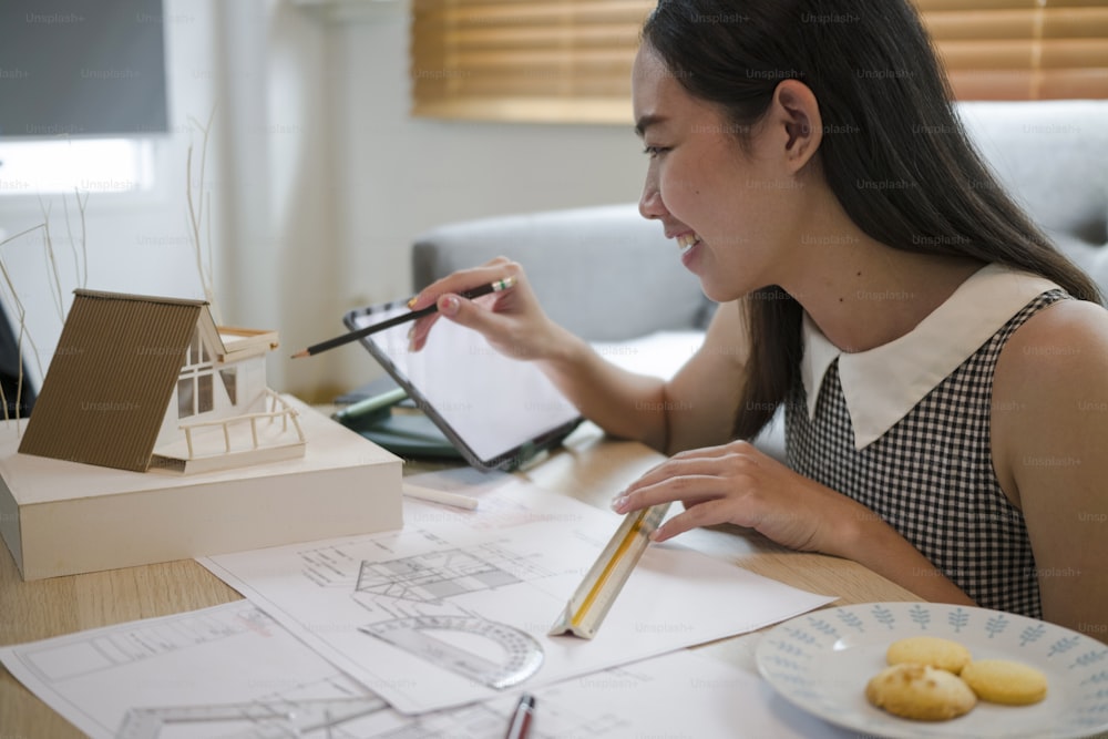 Female architect working with computer tablet at home.