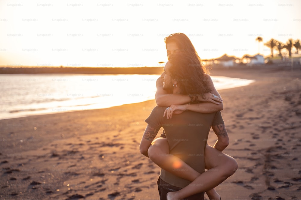 Hermosa pareja joven encantadora en la playa viendo la puesta de sol. Emociones de personas reales. Amar. Modo de vida. Vibraciones isleñas de verano.