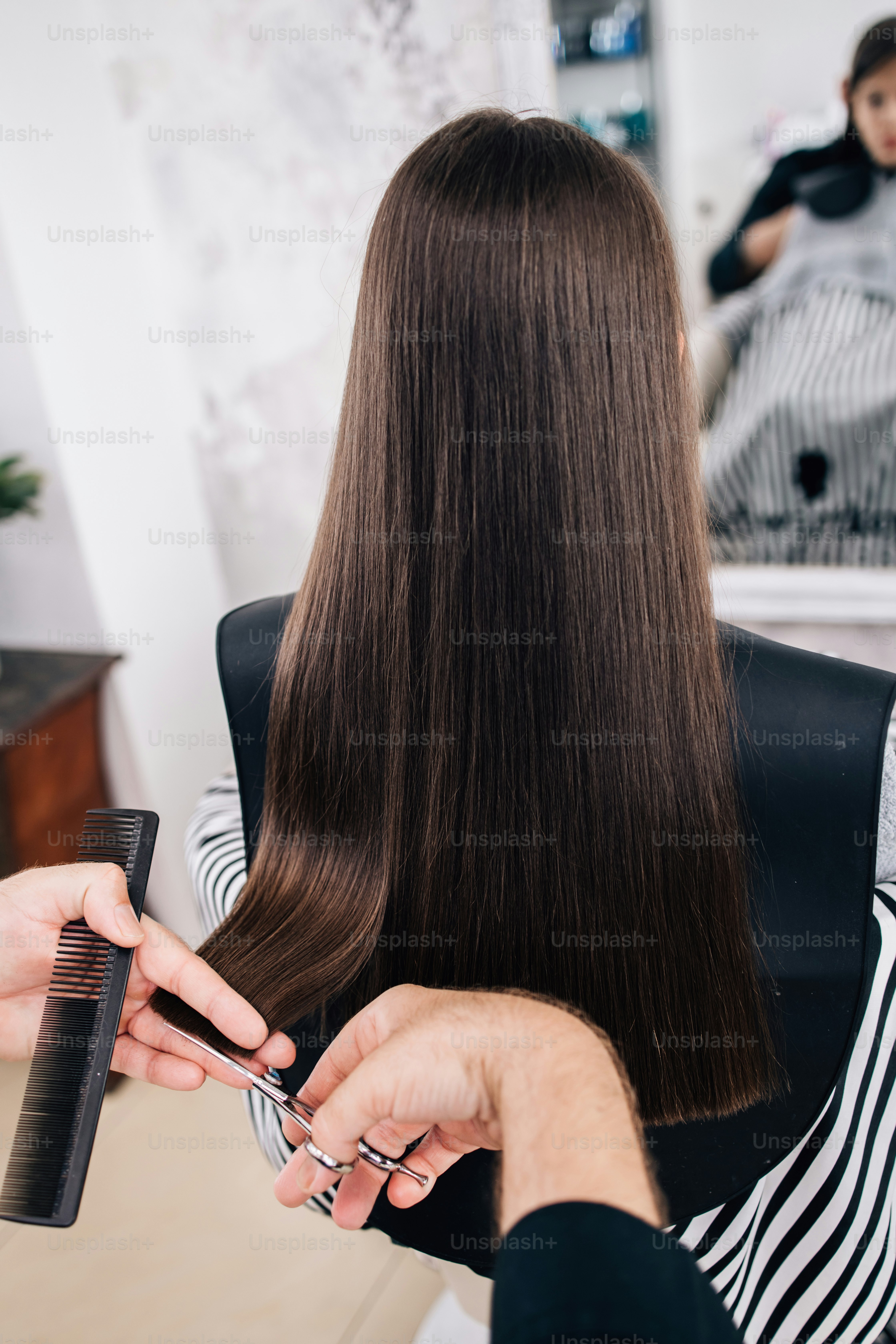 Gadis muda di perawatan gaya rambut sementara penata rambut profesional mencuci rambutnya dengan lembut.