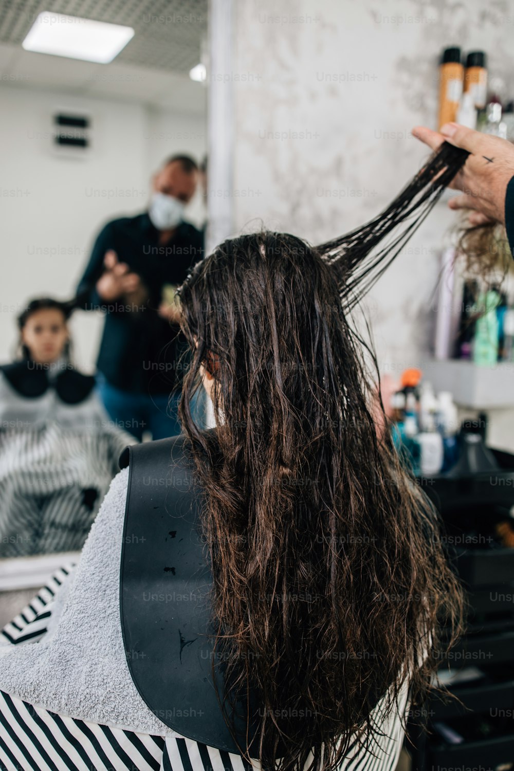 プロの美容師が優しく髪を洗っている間、髪型トリートメント中の若い女の子。
