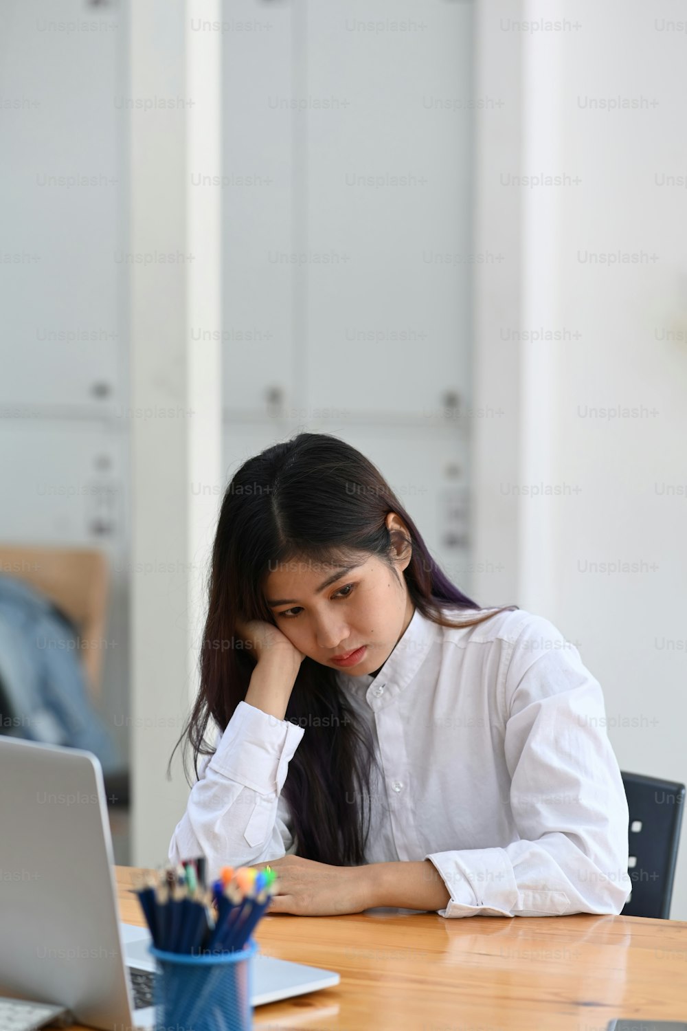 Fatigued businesswoman sitting at her desk in office.