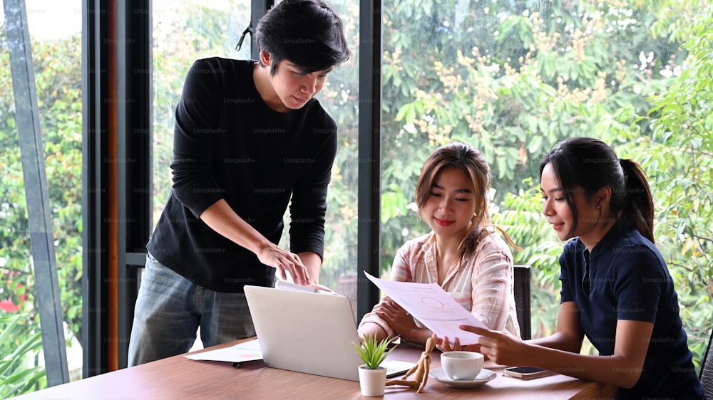 Business people analyzing some document and discussing project strategy together in office.