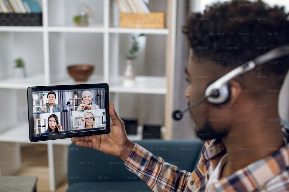 Man using tablet for video call with multiracial partners