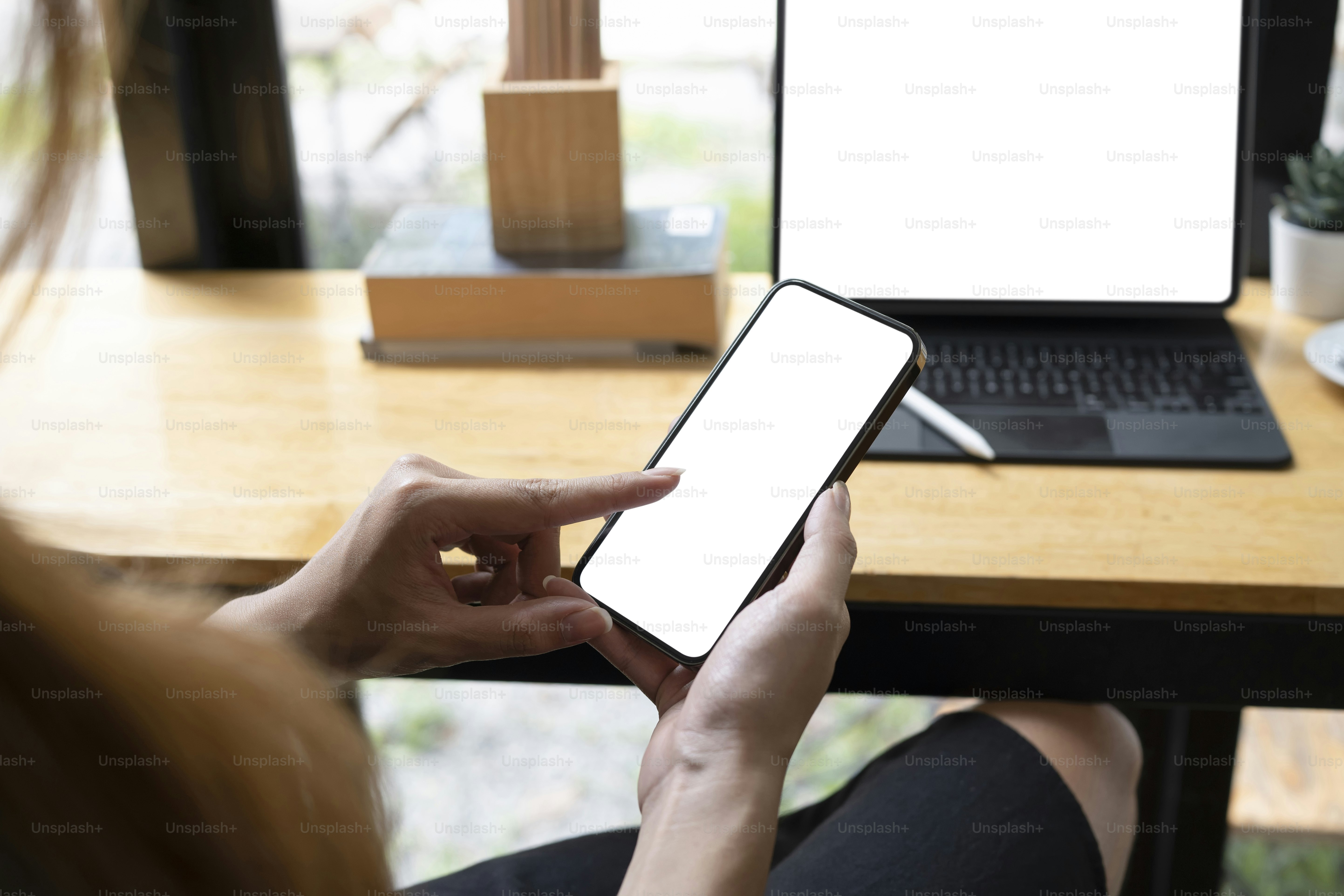 Cropped shot female sitting in cafe and using mobile phone.