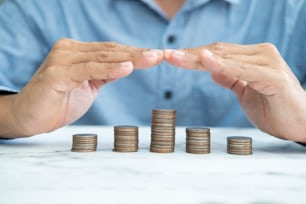 Savings protection, Protect money, Risk management, close up of male hands covering coins.