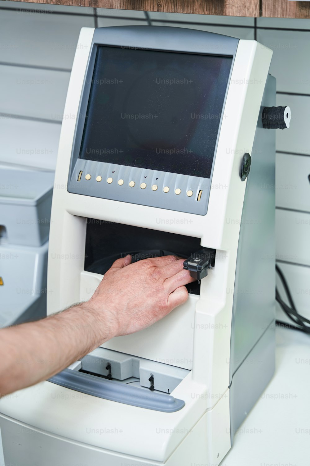 Close up of man hand using modern optical machine for eyeglasses repair