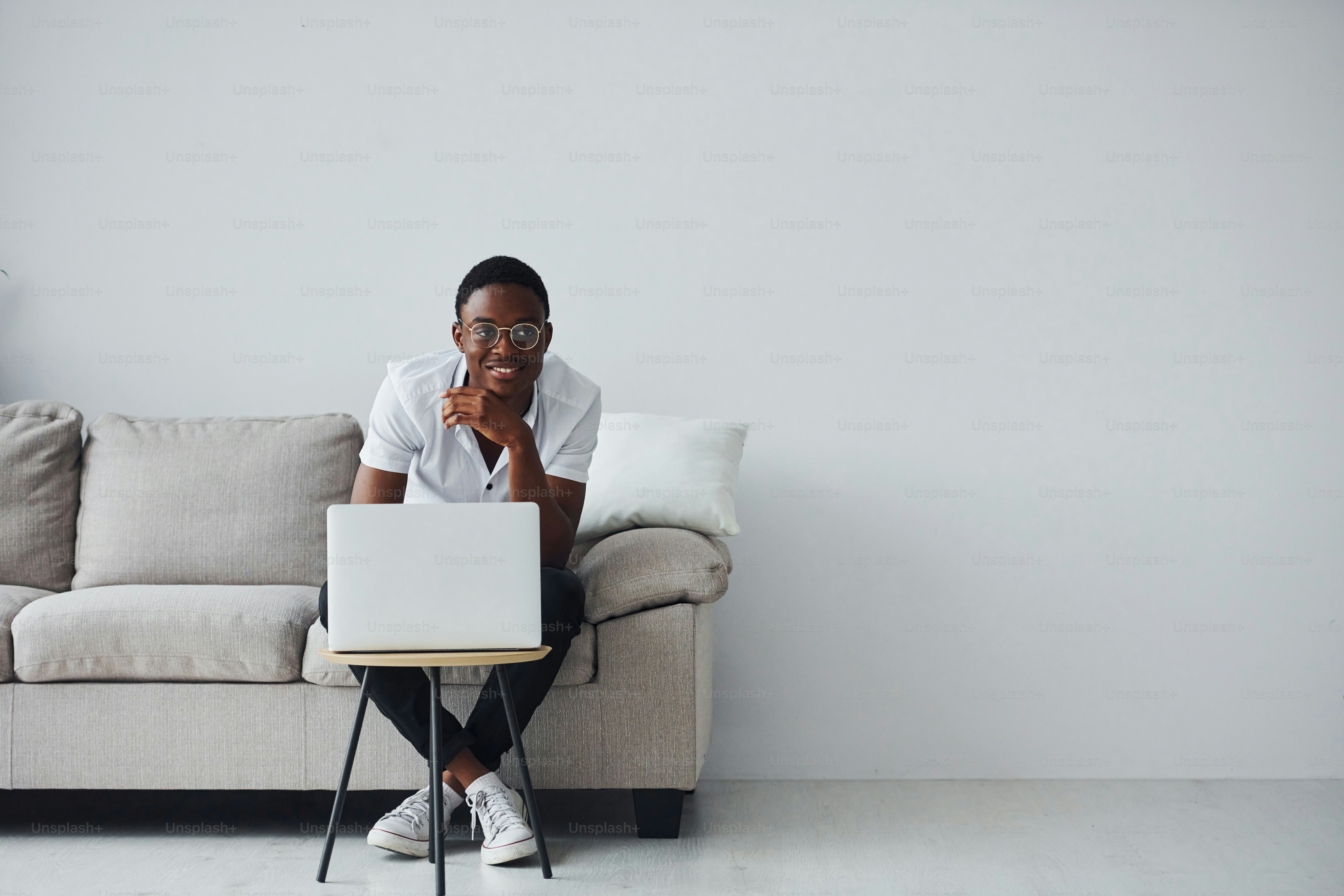 Young african american man in formal clothes indoors with laptop in hands.