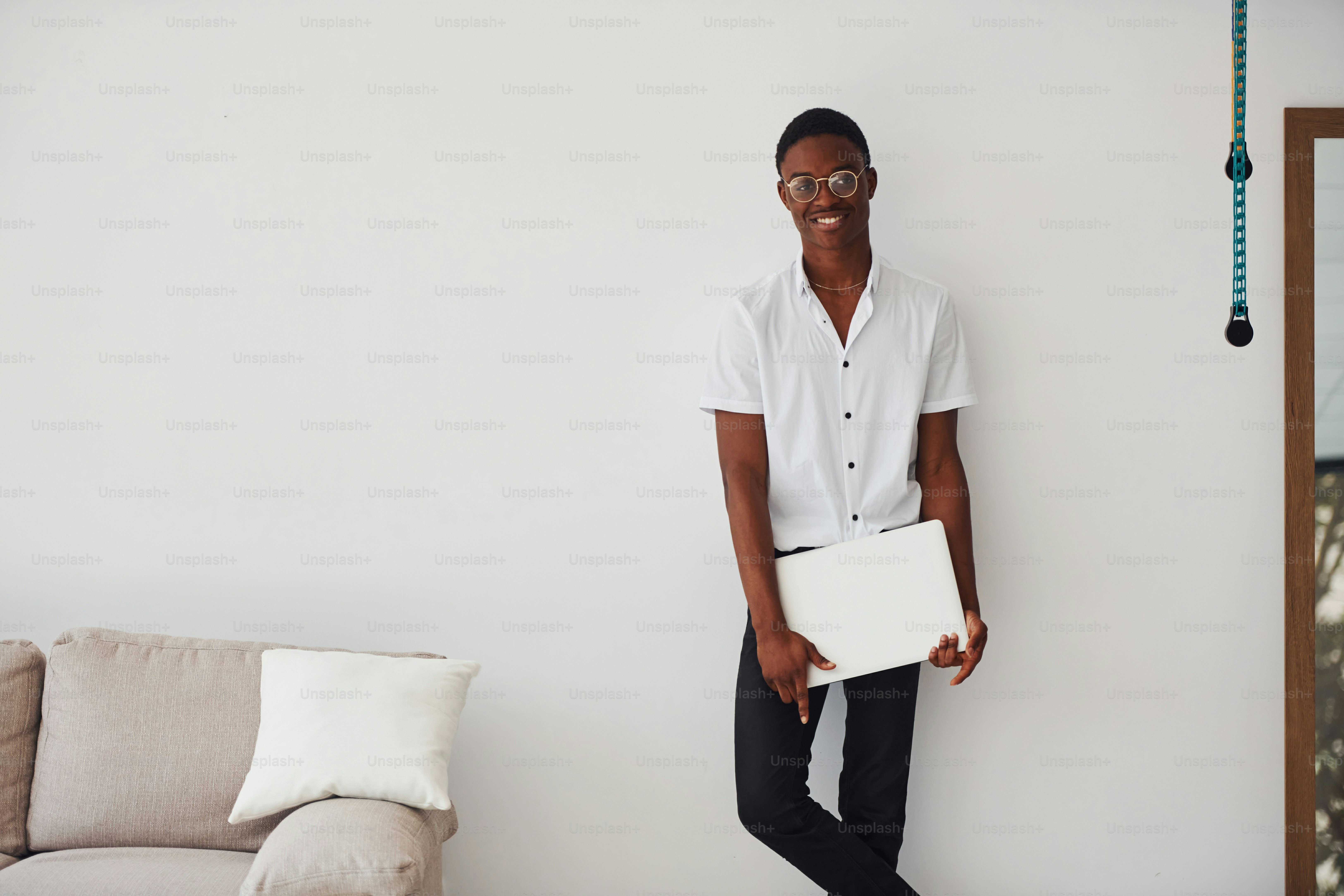Young african american man in formal clothes indoors with laptop in hands.