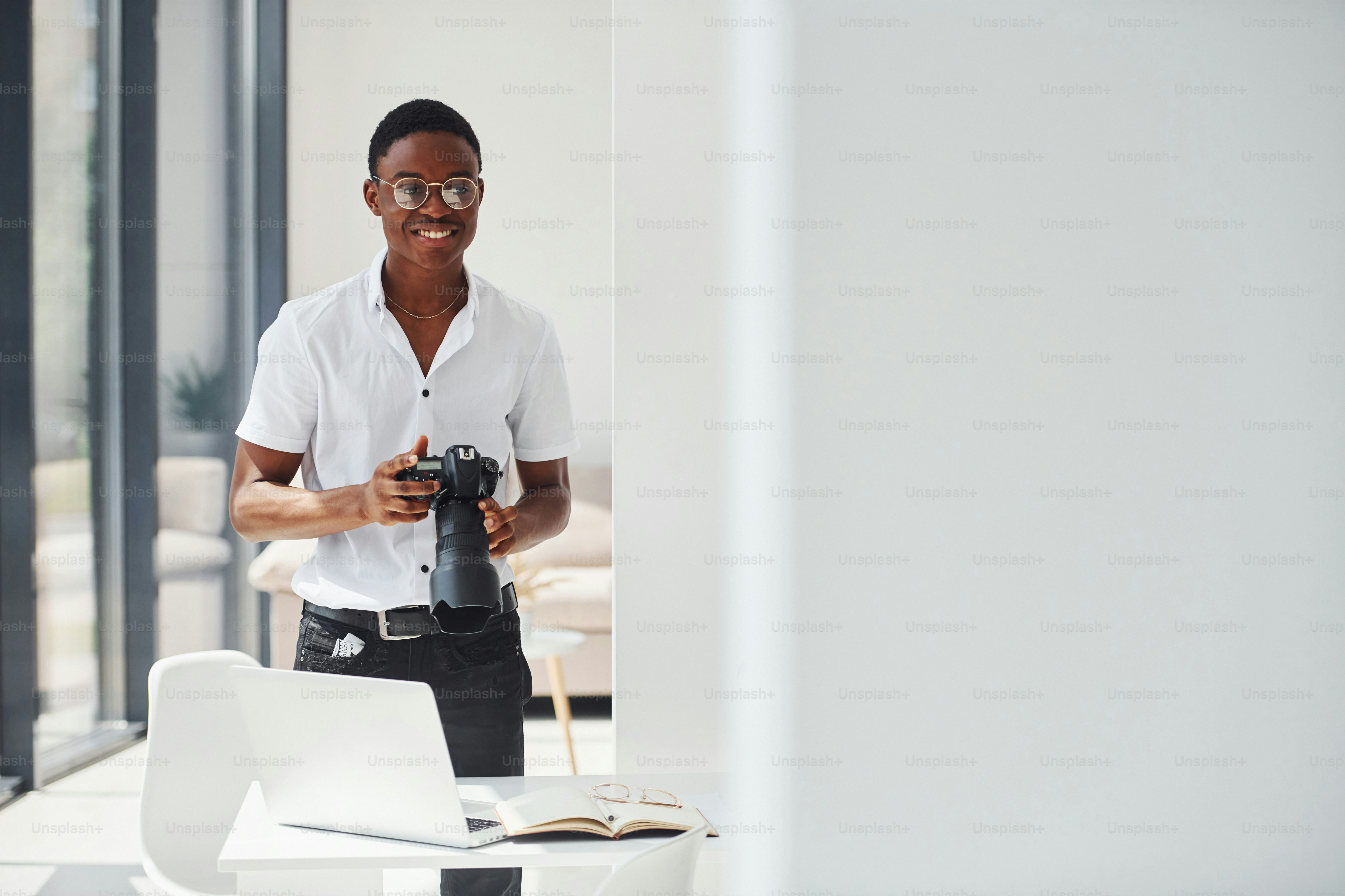 Testing camera. Young african american man in formal clothes is in the office.
