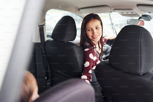 Madre con su hija dentro de un automóvil moderno juntos.