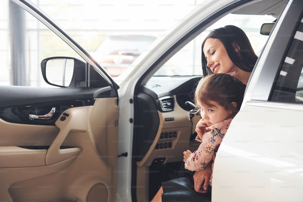 Mère avec sa fille à l’intérieur d’une voiture moderne ensemble.