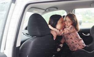 抱き合う。現代の自動車の中に娘を乗せた母親。