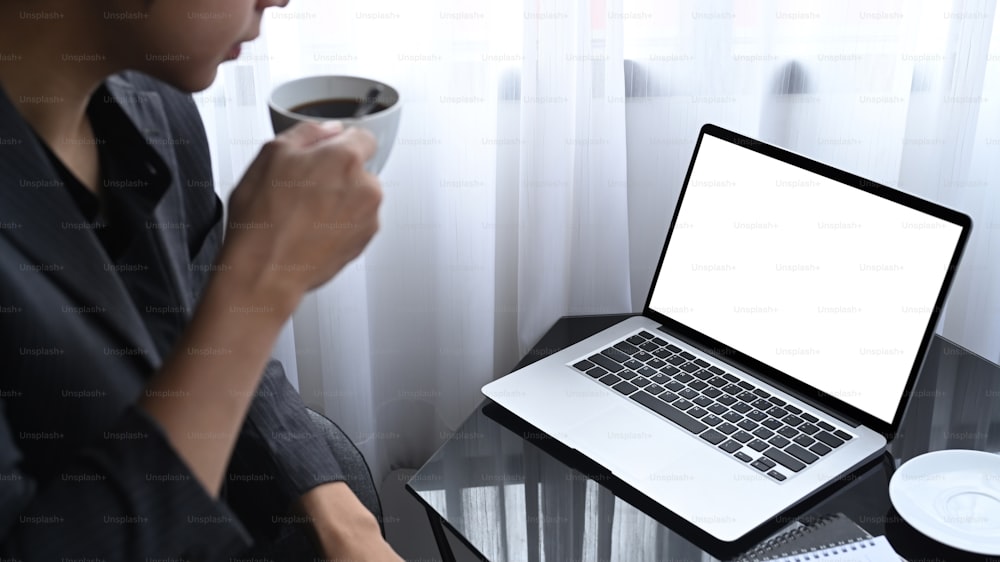 Thoughtful businessman drinking coffee and reading news on computer laptop.